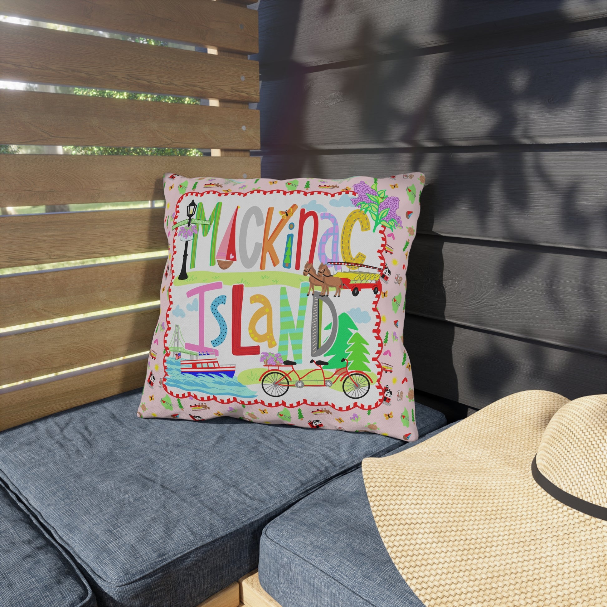 Mackinac Island outdoor throw pillow displayed on an outdoor patio bench.