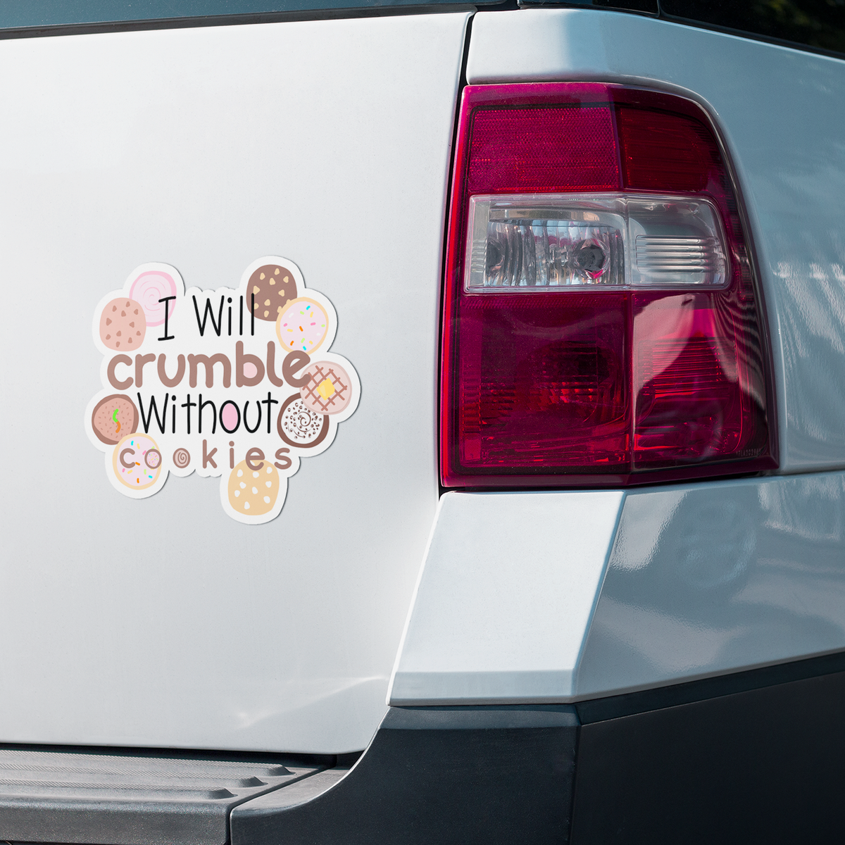 A die-cut vinyl sticker applied to the rear left side of a white vehicle, featuring the text 'I Will crumble Without cookies' surrounded by illustrated cookies and candies.